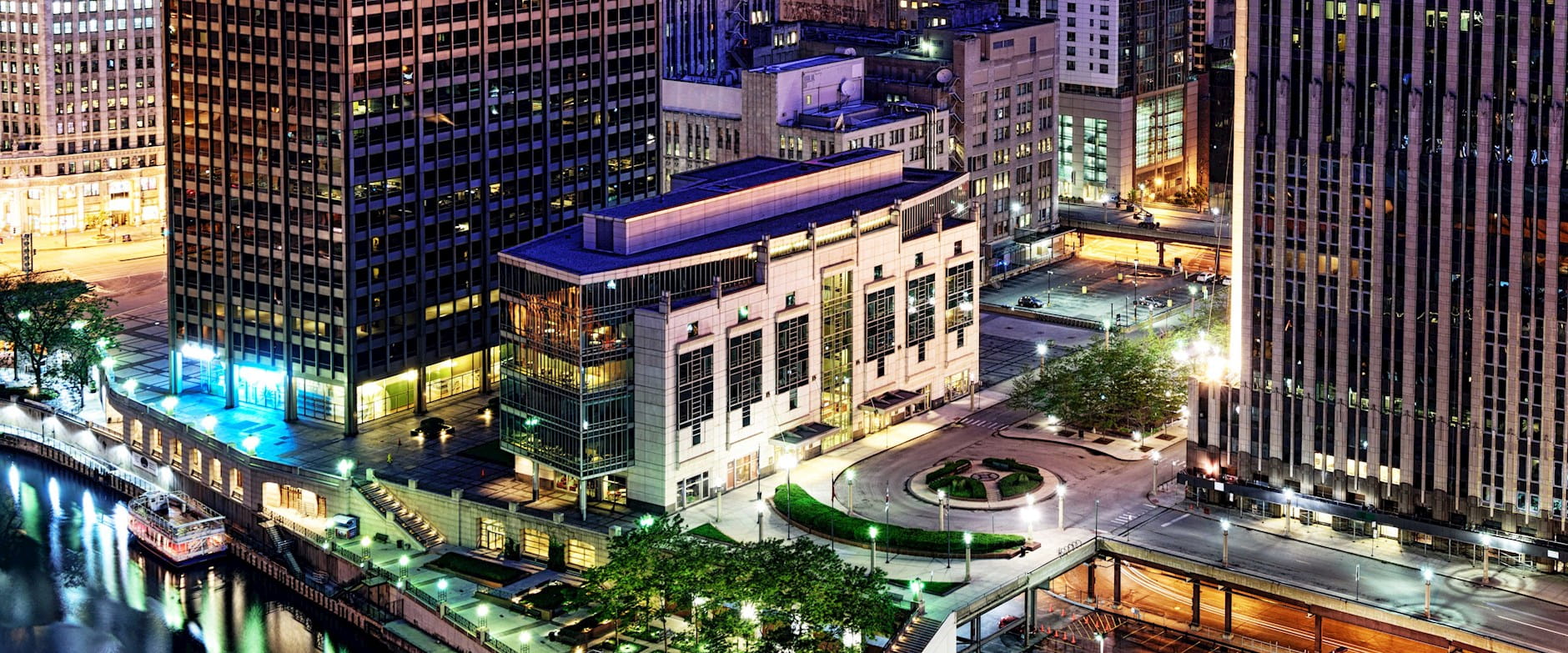 Aerial view of the Gleacher Center looking north west at dusk with Chicago architecture in the background 
