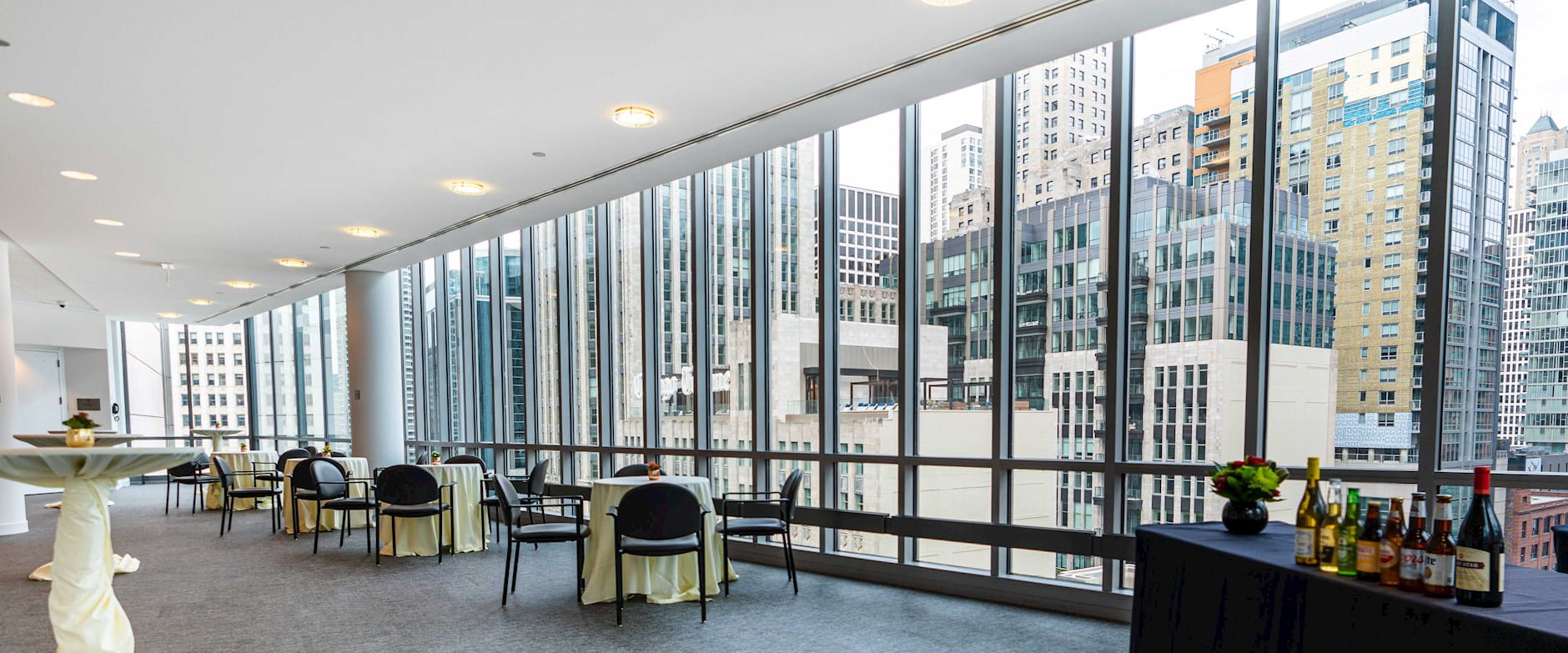 Gleacher Center reception room with bar and tables overlooking Chicago skyline