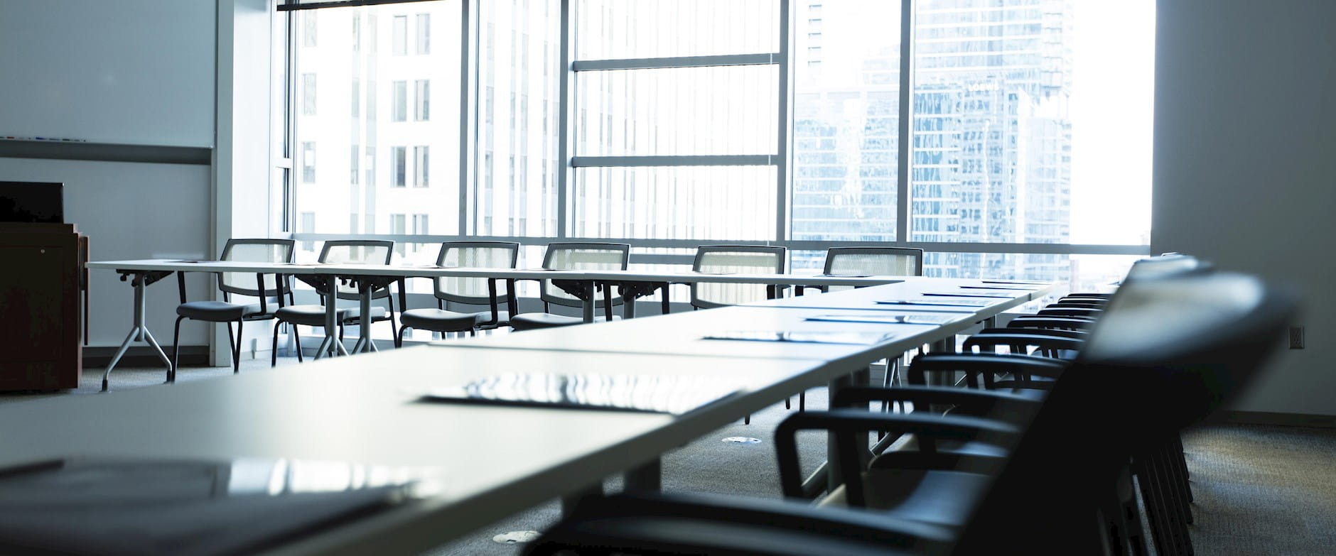 Room 422 in Gleacher Center showing part of the semi-circle of desks and chairs and looking toward a bright window