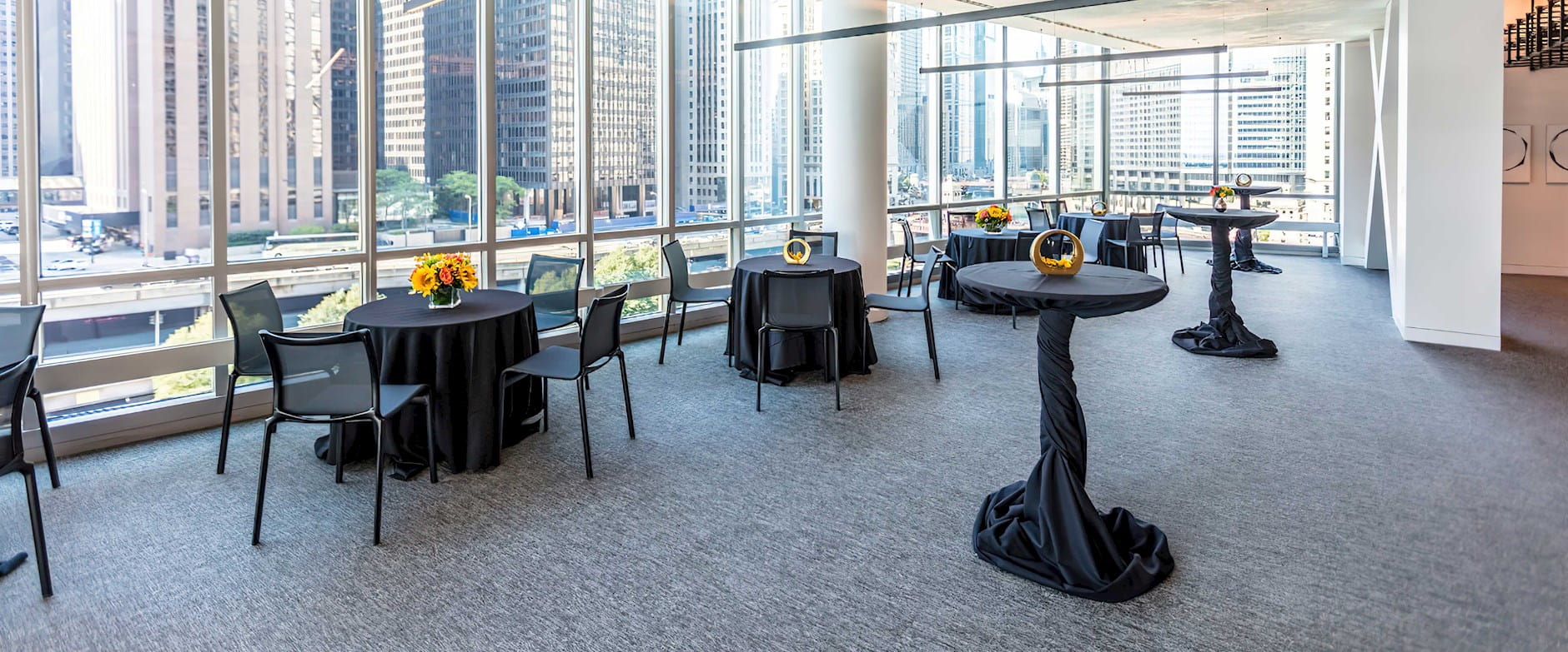 Veranda of the PIMCO Midway Club in Gleacher Center with brightly lit tables and floor to ceiling windows