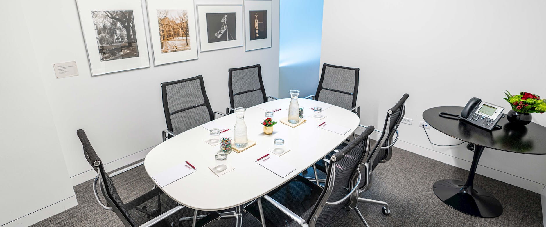 Small boardroom with a six-person table set with notepads